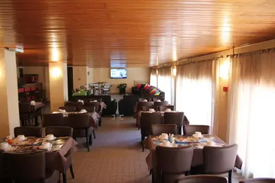 a dining room with tables and chairs in a restaurant at Hôtel Sampiero Corso in Corte