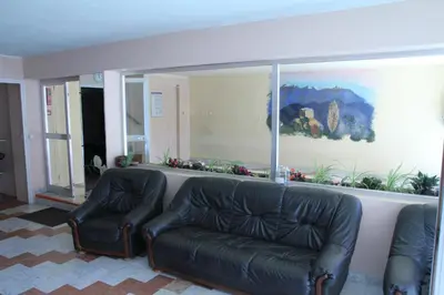 a living room with two leather chairs and a large window at Hôtel Sampiero Corso in Corte