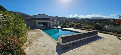 a swimming pool with a bench next to a house at Villa de standing Les Amandiers, vue mer & piscine in Propriano