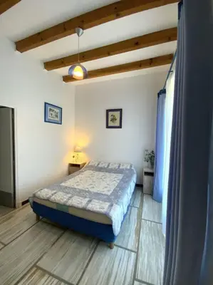 a bedroom with a bed and a television in it at Appartement en rez de villa in Aregno