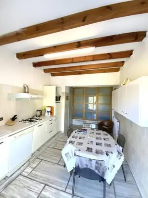 a kitchen with a table in the middle of a room at Appartement en rez de villa in Aregno