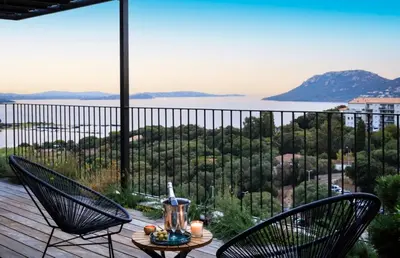 a patio with two chairs and a table with candles at Penthouse Les Oliviers in Porto-Vecchio