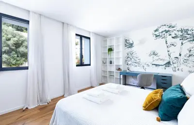 a white bedroom with a bed and a desk at Penthouse Les Oliviers in Porto-Vecchio