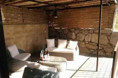 a patio with a couch and chairs and a table at Bergerie Nepita Oasis Rustique and Private Pool in Porto-Vecchio