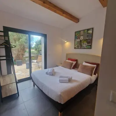 a bedroom with a bed and a large window at Bergerie Nepita Oasis Rustique and Private Pool in Porto-Vecchio