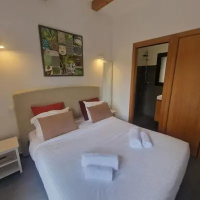 a bedroom with a large white bed with two towels on it at Bergerie Nepita Oasis Rustique and Private Pool in Porto-Vecchio