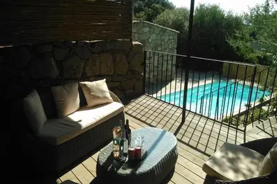 a patio with a couch and a table next to a pool at Bergerie Nepita Oasis Rustique and Private Pool in Porto-Vecchio