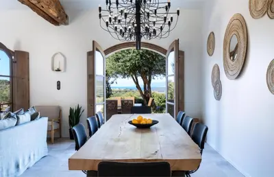 a dining room with a table and chairs and a chandelier at Villa Occhinello in Propriano