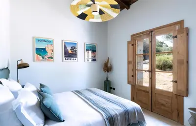 a bedroom with a bed and a wooden door at Villa Occhinello in Propriano
