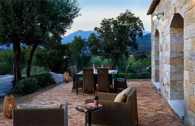 a patio with a table and chairs on a brick patio at Villa Occhinello in Propriano