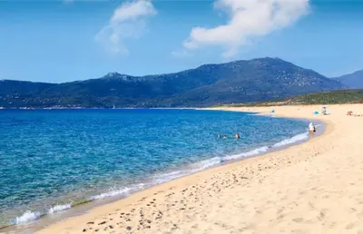 a beach with people swimming in the water at Villa Occhinello in Propriano