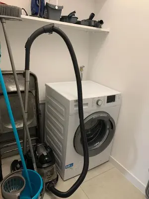 a washing machine with a hose next to a washer at Superb flat with a lovely view of the mountains in Porto-Vecchio