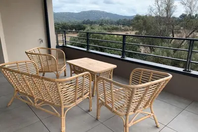 two chairs and a table on a balcony with a view at Superb flat with a lovely view of the mountains in Porto-Vecchio