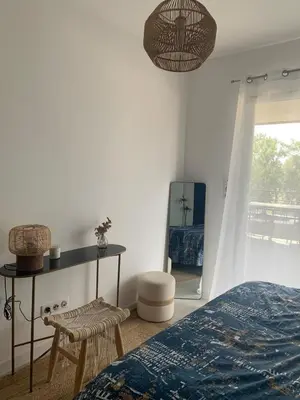 a bedroom with a bed and a table and a mirror at Superb flat with a lovely view of the mountains in Porto-Vecchio