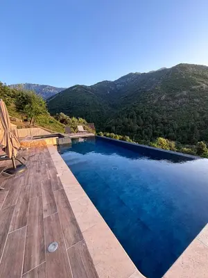 a swimming pool with a view of the mountains at Gîte A Funtana Montestremo, Balagne, Haute Corse in Manso