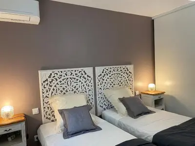 two beds in a room with two tables and two lamps at Gîte A Funtana Montestremo, Balagne, Haute Corse in Manso
