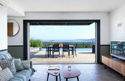 a living room with a couch and a tv and a patio at Villa Nepita in Lecci