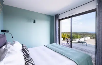a bedroom with a bed and a view of a deck at Villa Nepita in Lecci