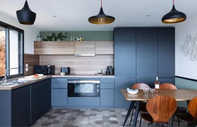 a kitchen with blue cabinets and a wooden table at Villa Nepita in Lecci