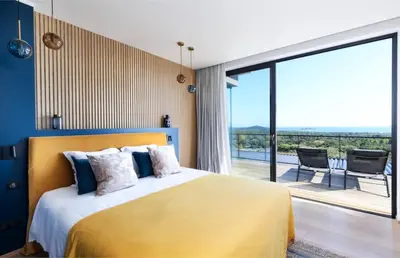 a bedroom with a yellow bed with a large window at Villa Nuciola in Lecci