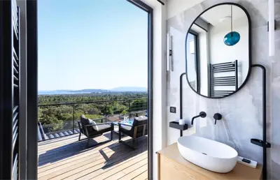 a bathroom with a sink and a balcony with a view at Villa Nuciola in Lecci