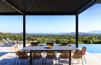 a dining table and chairs on a patio with a view at Villa Nuciola in Lecci