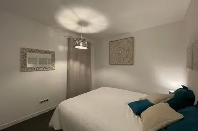a bedroom with a white bed with blue pillows at Two-bedroom flat with terrace near the harbour and town centre in Porto-Vecchio