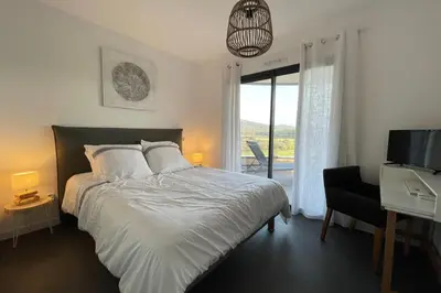 a bedroom with a bed and a desk and a television at Two-bedroom flat with terrace near the harbour and town centre in Porto-Vecchio