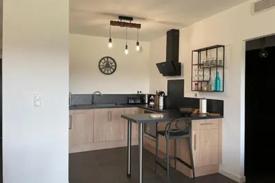 a kitchen with a table and a clock on the wall at Two-bedroom flat with terrace near the harbour and town centre in Porto-Vecchio