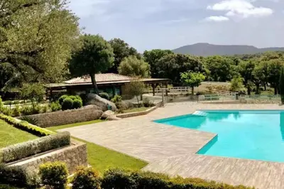 a swimming pool in a garden with a house at Rez de jardin dans une résidence de charme ... in Porto-Vecchio