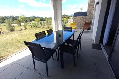 a blue table and chairs on a patio at Rez de jardin dans une résidence de charme ... in Porto-Vecchio