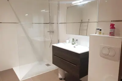 a white bathroom with a sink and a shower at Rez de jardin dans une résidence de charme ... in Porto-Vecchio