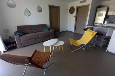 a living room with yellow chairs and a couch at Rez de jardin dans une résidence de charme ... in Porto-Vecchio