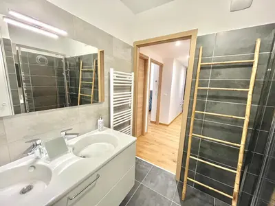 a bathroom with a sink and a mirror and a shower at Les terrasses de Toretta in Ajaccio