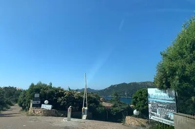a road with a sign next to a lake at Charming Duplex In Porto Vecchio in Porto-Vecchio