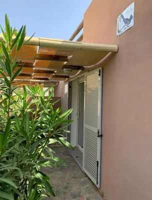a door to a building with awning on the side at Charming Duplex In Porto Vecchio in Porto-Vecchio