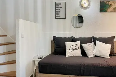 a bedroom with a bed with pillows on it at Charming Duplex In Porto Vecchio in Porto-Vecchio