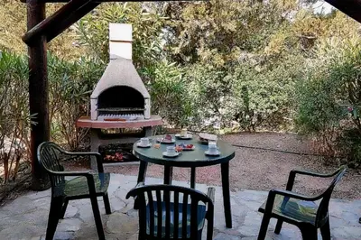 a table with two chairs and a table with a fireplace at Charming Duplex In Porto Vecchio in Porto-Vecchio