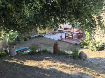 a garden with a picnic table and a bench under a tree at SEJOUR DETENTE BALAGNE ENTRE MER ET MONTAGNE in Urtaca