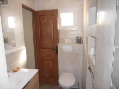 a bathroom with a toilet and a sink and a door at SEJOUR DETENTE BALAGNE ENTRE MER ET MONTAGNE in Urtaca