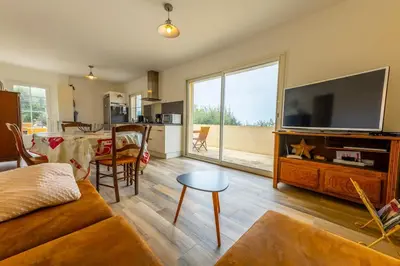 a living room with a large flat screen tv at SEJOUR DETENTE BALAGNE ENTRE MER ET MONTAGNE in Urtaca