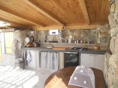 a kitchen with a stove and a counter top at SEJOUR DETENTE BALAGNE ENTRE MER ET MONTAGNE in Urtaca