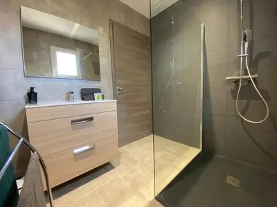 a bathroom with a glass shower and a sink at Monte Santu T2 in Prunelli-di-Fiumorbo