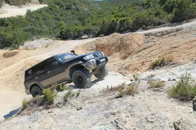 a black truck driving on a dirt road at Monte Santu T2 in Prunelli-di-Fiumorbo