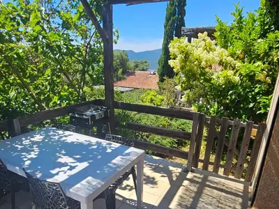 a table and chairs on a patio with a view of a garden at Villa 78 Alba Rossa Piscine chauffée et Plage de Cupabia in Serra-di-Ferro