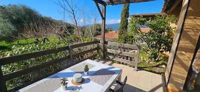a table and chairs on a patio with a fence at Villa 78 Alba Rossa Piscine chauffée et Plage de Cupabia in Serra-di-Ferro