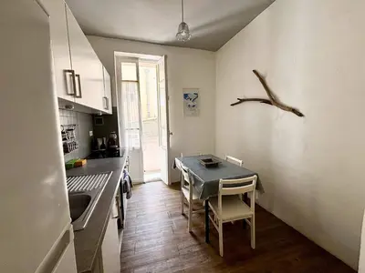 a kitchen with a table and a bird on the wall at Casamea - Escapade en bord de mer, Accès plage in Ajaccio