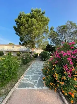 a garden with flowers and a walk way at Appartement à Cala Rossa in Lecci