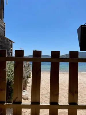 a view of the beach from a wooden fence at Appartement à Cala Rossa in Lecci
