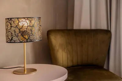 a lamp sitting on a table next to a chair at Hôtel Casa Matteu in Afa